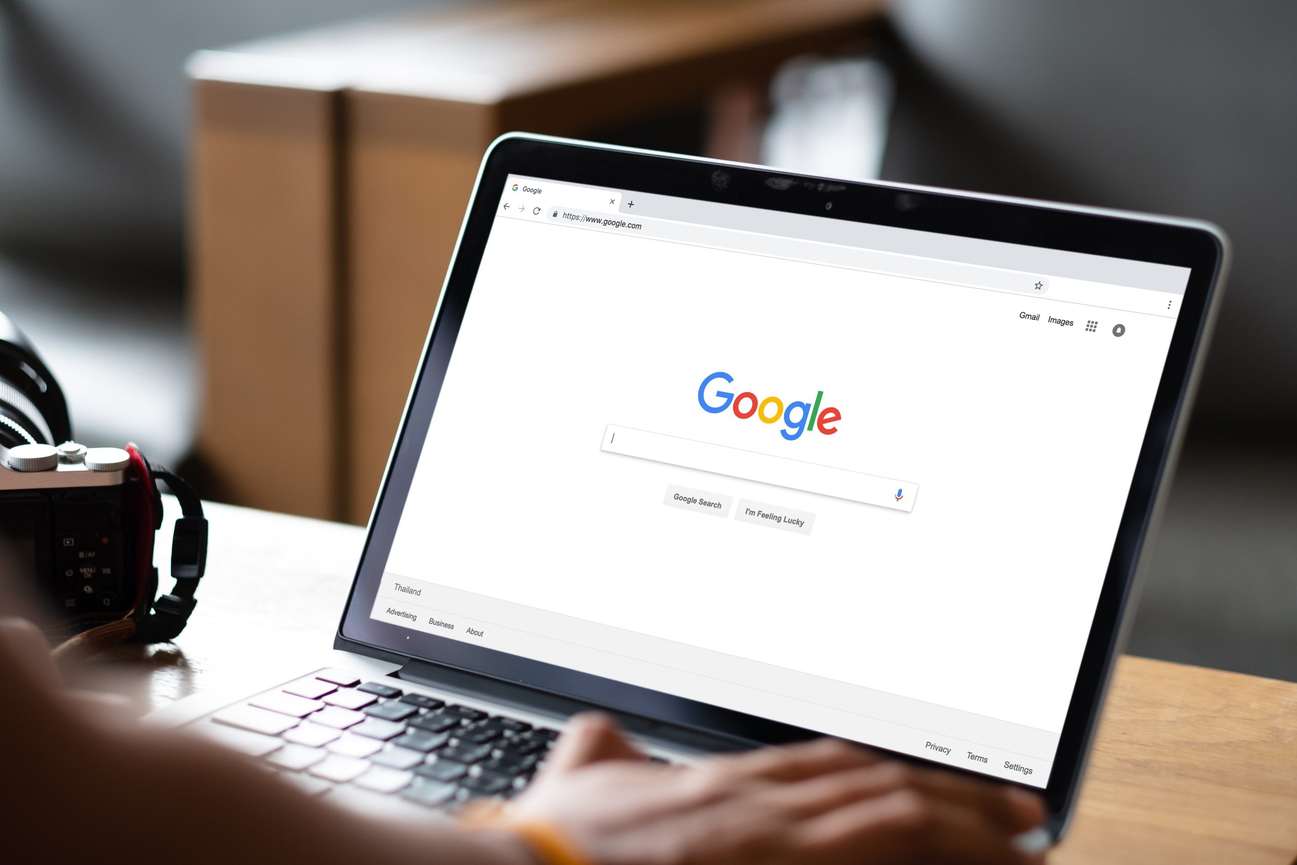 A man typing a query into Google search on a laptop – a demonstration of how Social SEO works.