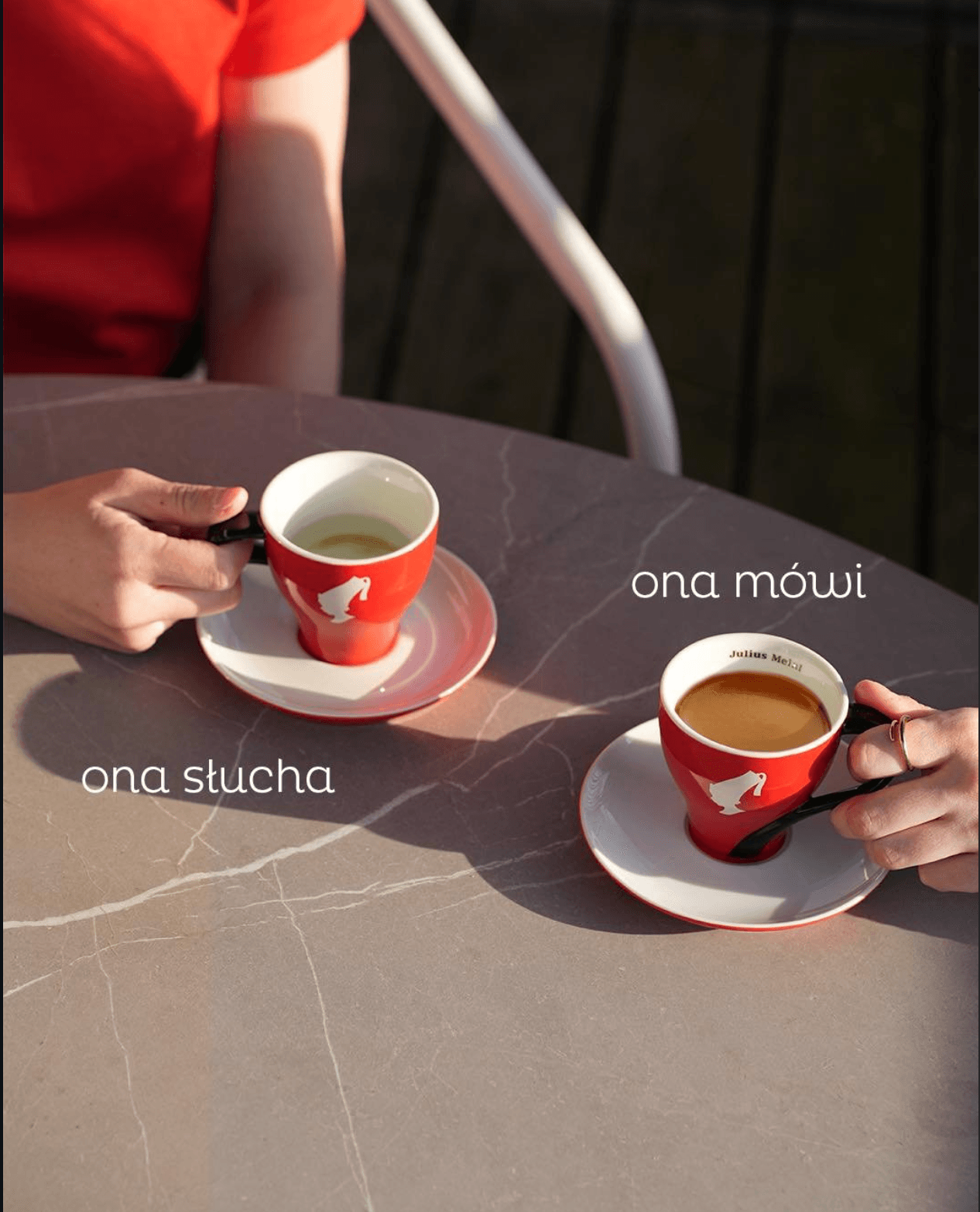 Two Julius Meinl cups on a cafe table, the "she talks, she listens" creative